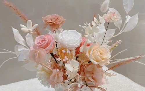 A large bouquet of flesh-pink preserved flowers consisting of orange leaves, roses, pampas and carnations category